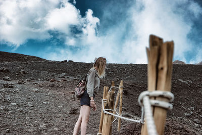 Woman standing on mountain against sky