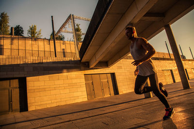 Man walking on bridge in city