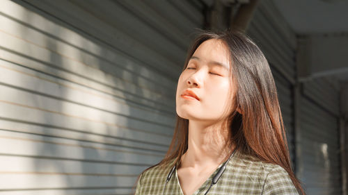 Young woman with eyes closed standing outdoors