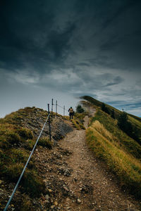 Rear view of woman walking on road against sky