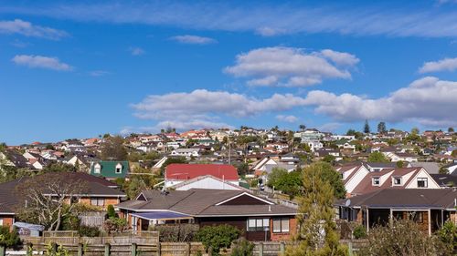 Houses in city against cloudy sky