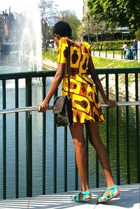 Full length of woman standing against railing