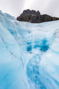 Scenic view of frozen mountains against sky