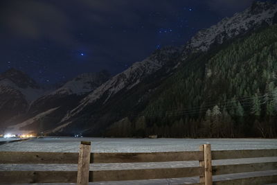 Scenic view of snowcapped mountains against sky at night