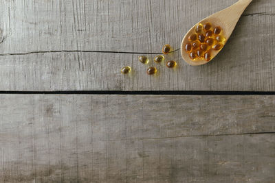 Flat lay with omega 3 capsules on spoon on the wooden background. health concept. vitamin pills