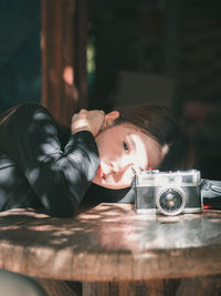 Portrait of man photographing with camera on table