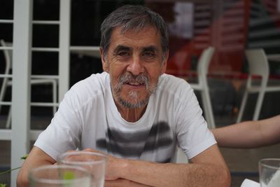 Portrait of smiling senior man sitting at sidewalk cafe