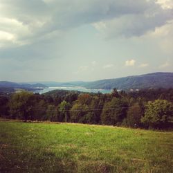 Scenic view of grassy field against cloudy sky