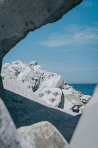 Close-up of rocky beach against blue sky