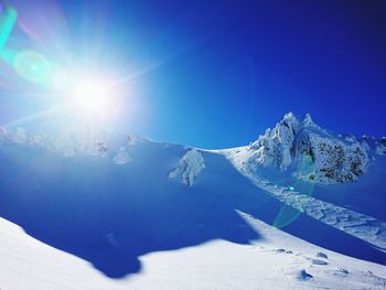 Scenic view of snowcapped mountains against clear blue sky during sunny day