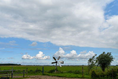 Scenic view of field against cloudy sky