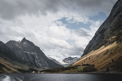 Scenic view of lake by mountains against sky