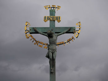 Low angle view of crucifix against sky
