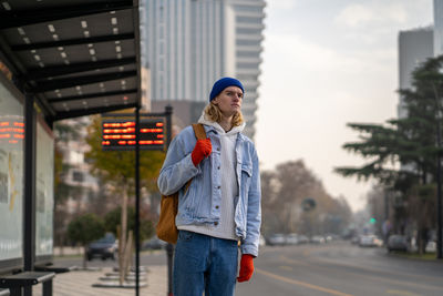 Portrait of young woman standing in city