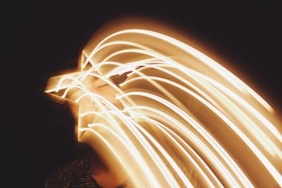 Light trails in star shape covering man face at night