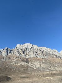 Scenic view of snowcapped mountains against clear blue sky