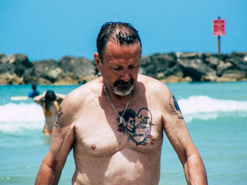 Midsection of shirtless man at beach