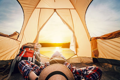 People at tent against sky during sunset