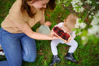 Mother and daughter eat jam bread at a picnic spring