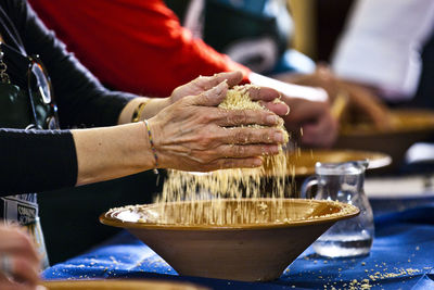 Close-up side view of hands kneading dough