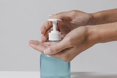 Close-up of hand holding glass over white background