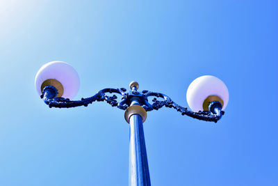 Low angle view of ferris wheel against blue sky