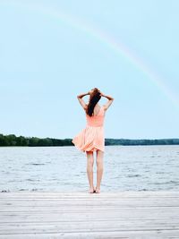 Woman standing on pier by lake