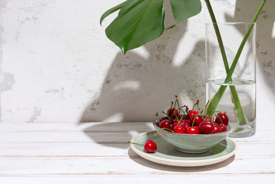 Red berries on table against wall