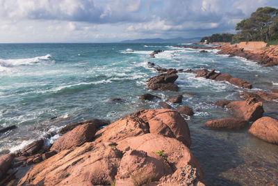 Scenic view of rocks on beach against sky