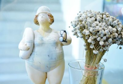 Female figurine with flower vase