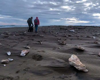 Rear view of women on beach against sky