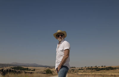 Adult man in cowboy hat on dirt road against sky. castilla y leon, spain