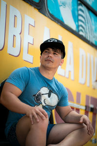 Portrait of young man sitting and looking away.