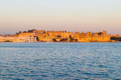 View of city by sea against clear sky