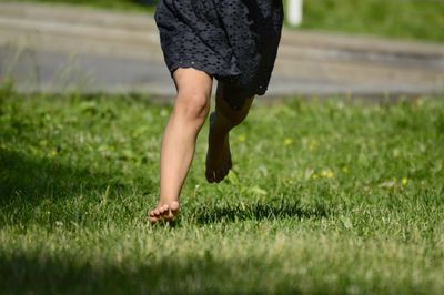 Low section of woman running on lawn