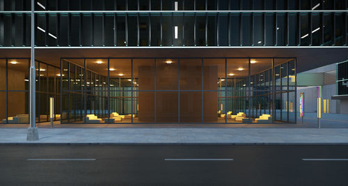 Empty parking lot by building at night