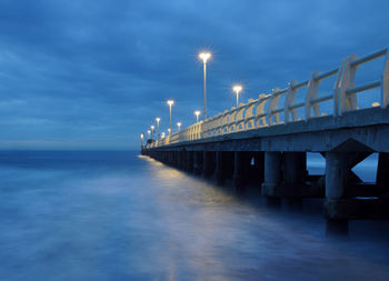 Bridge over sea against blue sky