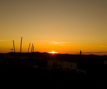 Silhouette built structures against sky during sunset