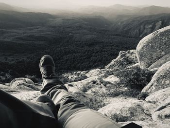 Low section of person relaxing on rock