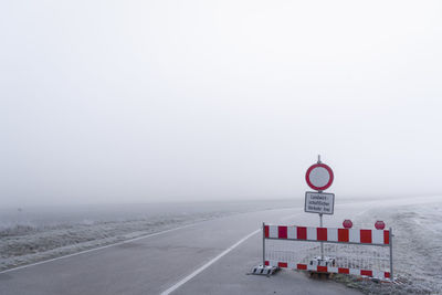 Road sign against sky