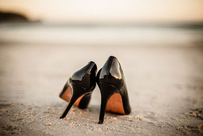 Close-up of shoes on beach