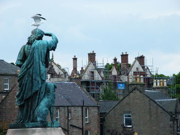 Statue of building against cloudy sky