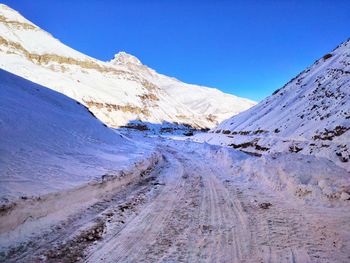 Scenic view of snowcapped mountains against clear blue sky