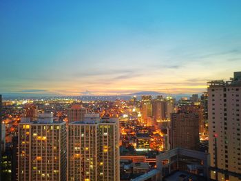 Illuminated buildings in city against sky