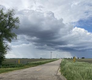 Road amidst field against sky