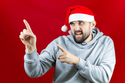 Midsection of man wearing mask against red background