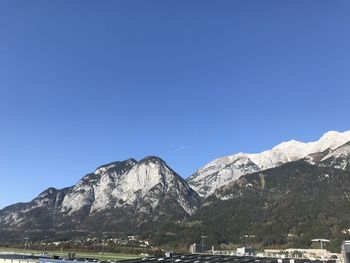 Scenic view of snowcapped mountains against clear blue sky