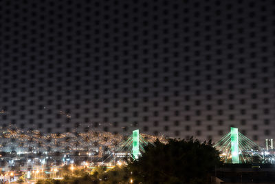 Low angle view of illuminated city against sky at night