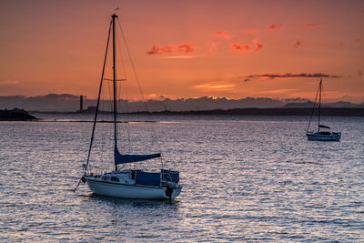 Sailboat on sea against sky during sunset