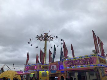 Low angle view of carousel against sky